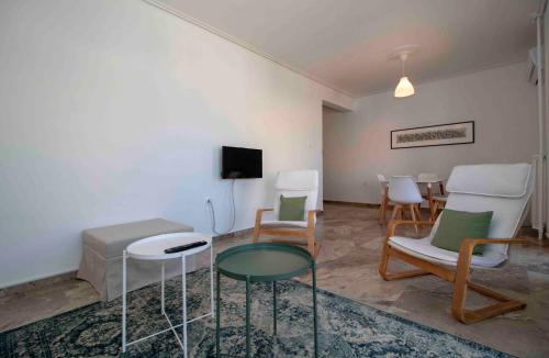 a living room with chairs and a table and a tv at Laconian Collection #Othonos luxury apartment# in Sparti