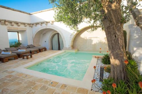 an indoor pool with a tree in a courtyard at La Sommità Relais & Chateaux in Ostuni