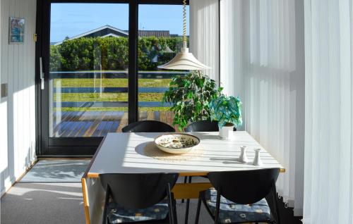uma mesa de jantar com cadeiras e uma tigela em Stunning Home In Hadsund With House Sea View em Hadsund