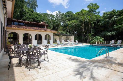 a patio with chairs and a swimming pool at Villa San Ignacio in Alajuela City