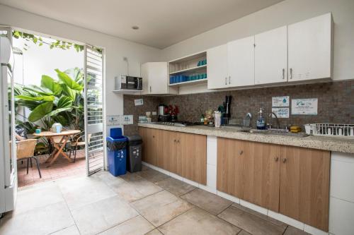 a kitchen with white cabinets and a counter top at Oasis Cali Hostel in Cali
