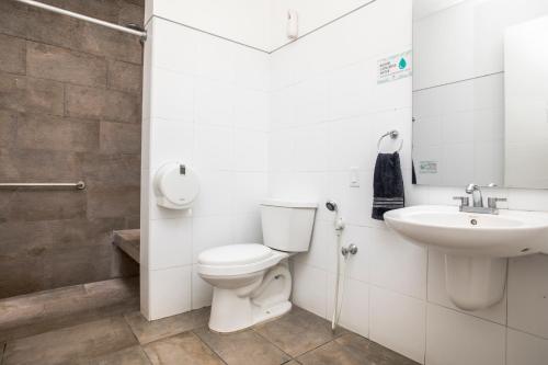 a bathroom with a toilet and a sink at Oasis Cali Hostel in Cali