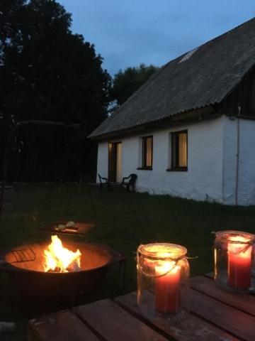 a fire pit in a yard with three lit candles at Domek blisko Biebrzy in Radziłów