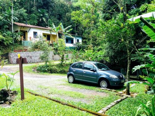 a blue car parked in front of a house at Pousada Arboretum in Penedo