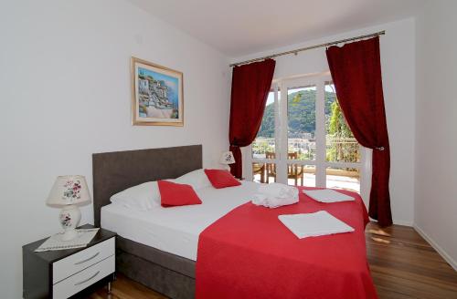 a bedroom with a bed with a red blanket at Apartments Petra in Dubrovnik