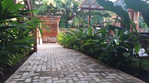 a brick walkway in a garden with plants at Conchas do Mar Residence in Itacaré