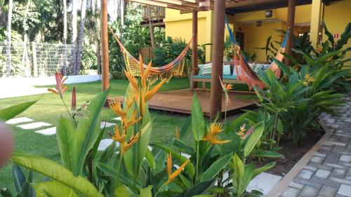 a garden with a hammock and some plants at Conchas do Mar Residence in Itacaré