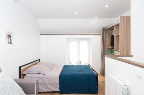 ein Schlafzimmer mit einem Bett mit einer blauen Decke darauf in der Unterkunft in the dream of Disneyland Paris in Serris