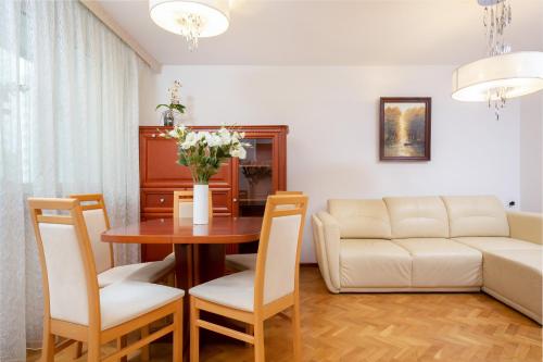 een woonkamer met een tafel en een bank bij Two-Bedroom Family Apartment Esperanto next to Klif by Renters in Warschau