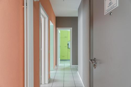a hallway with orange walls and a yellow door at Lido Apartments by Quokka 360 - 5 min from the centre and the Lugano Lido in Lugano