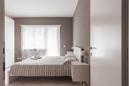 a bedroom with a bed and a window at Lido Apartments by Quokka 360 - 5 min from the centre and the Lugano Lido in Lugano