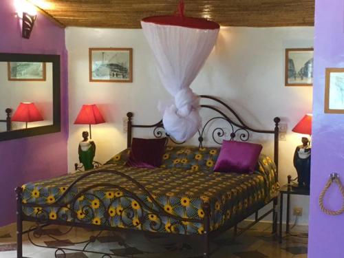 a bedroom with a bed with a dress on it at Maison Couleur Passion in Nianing