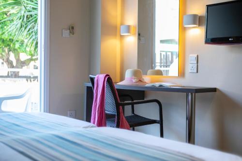 a bedroom with a desk and a bed and a mirror at Mayfair Gardens in Paphos City
