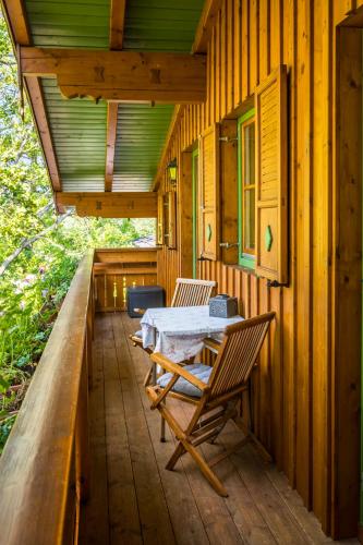 a wooden porch with a table and chairs on it at Starbauer in Golling an der Salzach