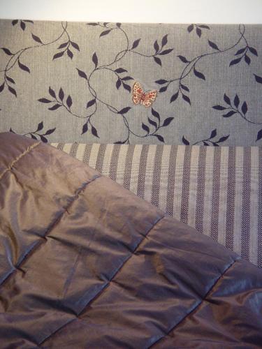a butterfly sitting on top of a bed with a blanket at Bella Tuscany Motor Lodge in Napier