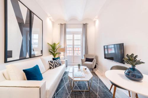 a living room with a white couch and a table at Genteel Home Plaza Mayor in Madrid