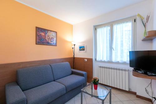 a living room with a blue couch and a tv at Residence La Collina in Vercana