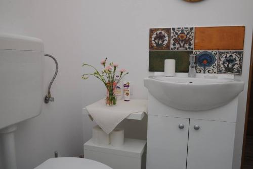 een witte badkamer met een wastafel en een toilet bij Sophie Apartment in Oradea