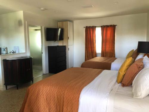 a hotel room with two beds and a flat screen tv at Captiva Beach Resort (open private beach access) in Sarasota