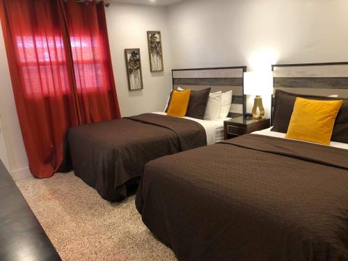 two beds in a room with red curtains and yellow pillows at Captiva Beach Resort (open private beach access) in Sarasota