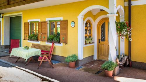 a yellow house with a table and a bench at Starbauer in Golling an der Salzach