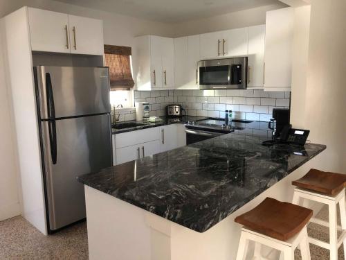 a kitchen with white cabinets and a black counter top at Captiva Beach Resort (open private beach access) in Sarasota