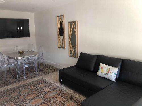 a living room with a black couch and a table at Captiva Beach Resort (open private beach access) in Sarasota