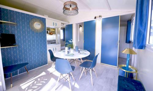 a dining room with blue walls and a table and chairs at Camping Site de Gorge Vent in Fréjus