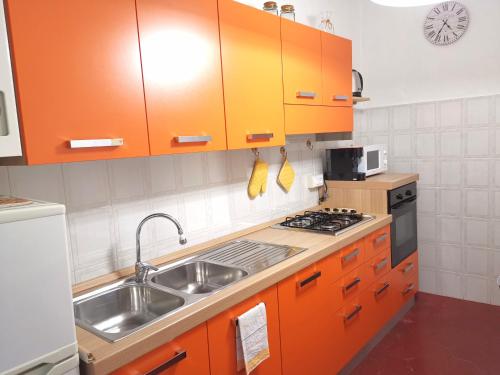 eine Küche mit orangefarbenen Schränken und einem Waschbecken in der Unterkunft Appartamento Liliana in Pontremoli