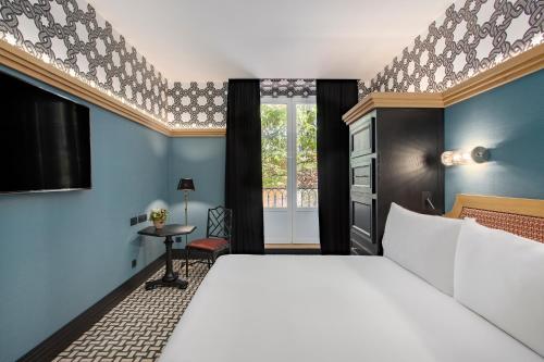 A bed or beds in a room at Room Mate Collection Alba, Madrid