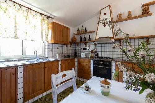 a kitchen with wooden cabinets and a table with a chair at Villa Aurelia in Ioppolo
