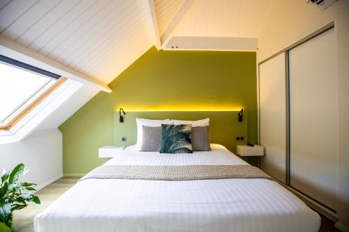 a bedroom with a large bed with a yellow wall at Centr'Hotel in Marigot