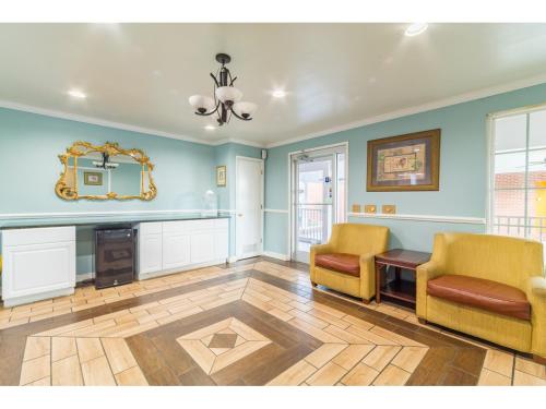 a living room with two chairs and a table and a mirror at Winton Inn & Suites in Barnwell
