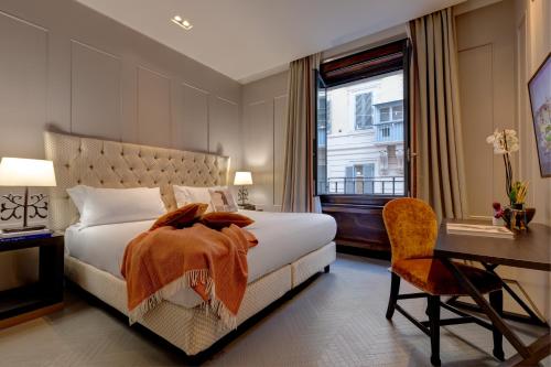 a bedroom with a bed and a desk and a window at Singer Palace Hotel in Rome