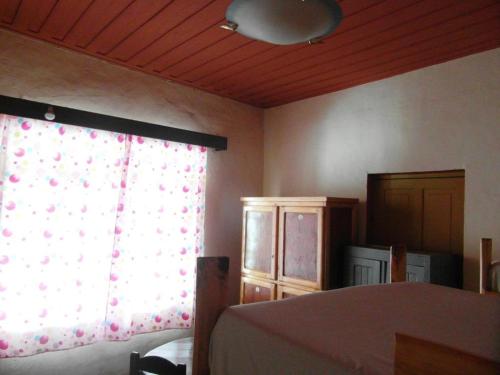a bedroom with a bed and a window with a curtain at Three Palms Fianar in Fianarantsoa