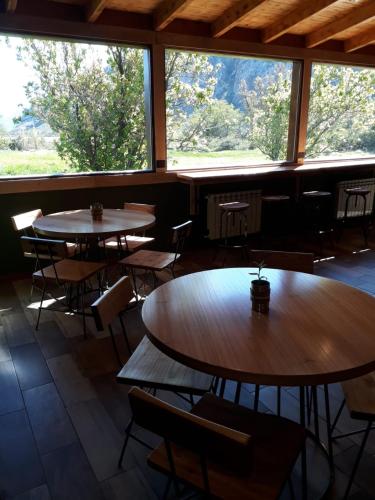 two tables and chairs in a room with windows at Fitz Roy Hostería de Montaña - El Chaltén in El Chalten