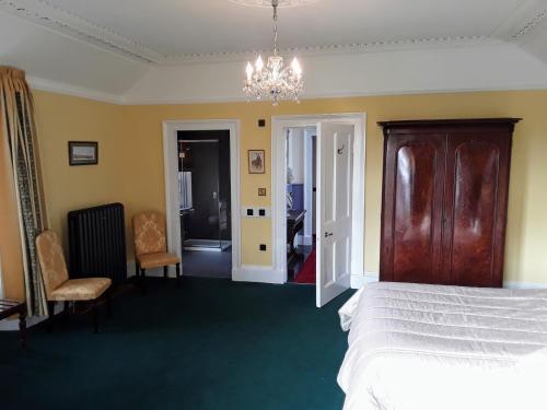 a bedroom with a bed and a chandelier at Kilmorie House in Elgin