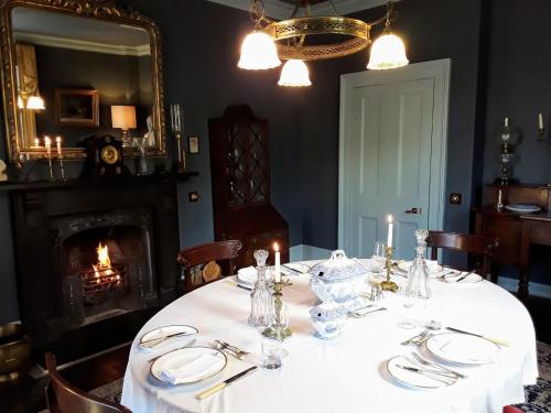 a dining room with a table with plates and candles at Kilmorie House in Elgin