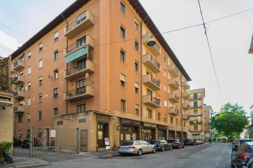 a large orange building with cars parked in front of it at Biasanòt Mini in Bologna