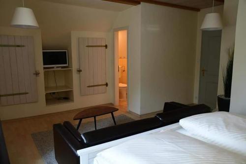 1 dormitorio con 1 cama y sala de estar con TV. en Hotel Berggasthof Waldlust, en Wunsiedel