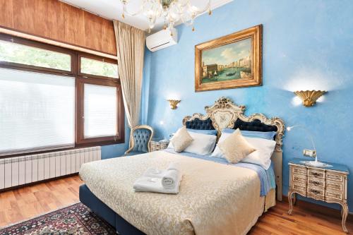 Un dormitorio azul con una cama con una toalla. en BB Venezia en Venecia