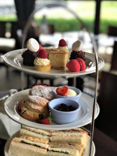 a three tiered tray of desserts and pastries on a table at Weald of Kent Golf Course and Hotel in Maidstone
