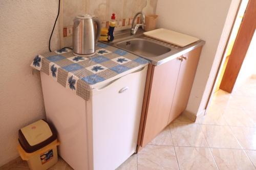 a small kitchen with a sink and a refrigerator at Bogdanoski Studios & Guest Rooms in Ohrid
