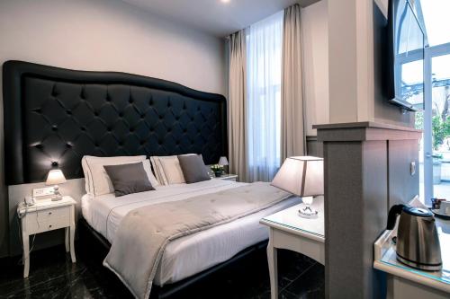 a bedroom with a large bed with a black headboard at Villa Elisio Hotel & Spa in Naples