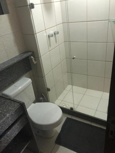 a bathroom with a toilet and a glass shower at Blue Marlin Cotovelo - Vista Vale - Reformado in Parnamirim