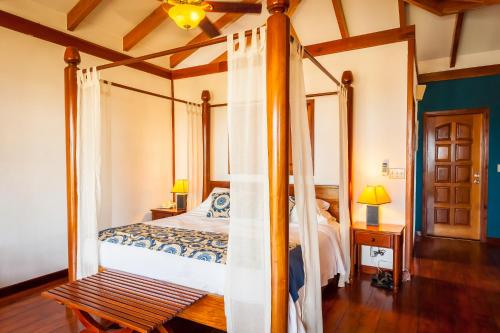 
a bedroom with a bed and a canopy at Hopkins Bay Belize a Muy'Ono Resort in Hopkins
