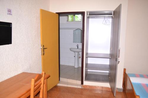 a bathroom with a door leading to a sink at Musanto Hotel in Gisenyi