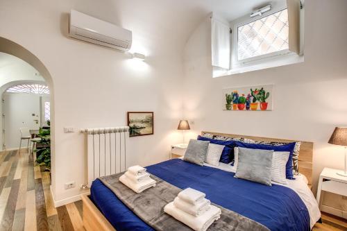 a bedroom with a large bed with blue sheets at FRESH HOUSE NAVONA in Rome