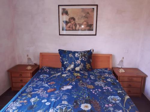 a bedroom with a bed with a blue comforter and two night stands at Ferienwohnung Thöne in Horstmar