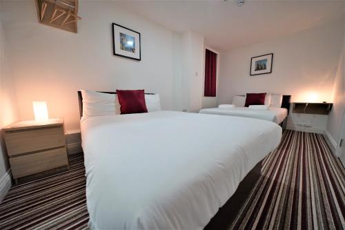 a hotel room with two large beds in it at TBH Hotel in Barking